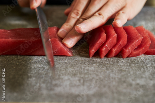 Slicing tuna saku block with sashimi knife
