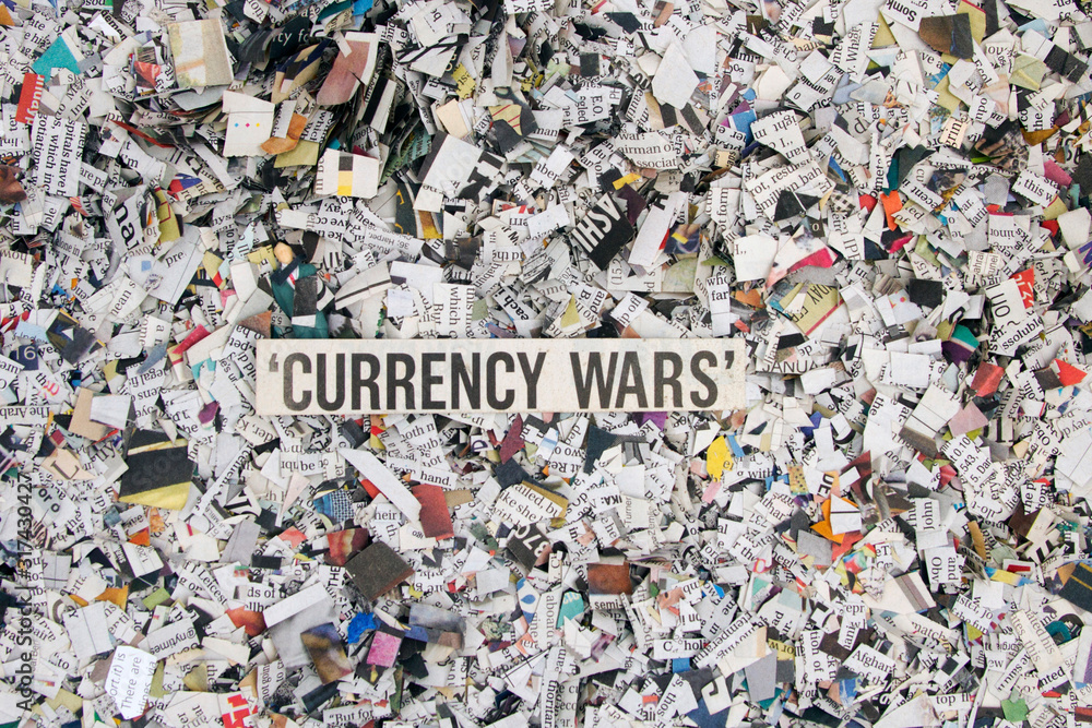 Newspaper confetti from above with the word CURRENCY WARS  WARS