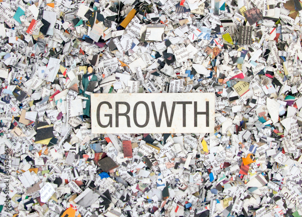 Naklejka premium Newspaper confetti from above with the word GROTH
