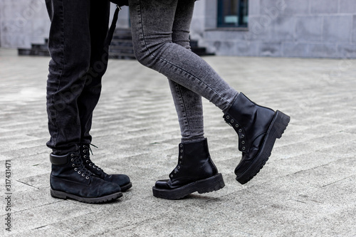 Legs of a young couple in love kissing on the street.