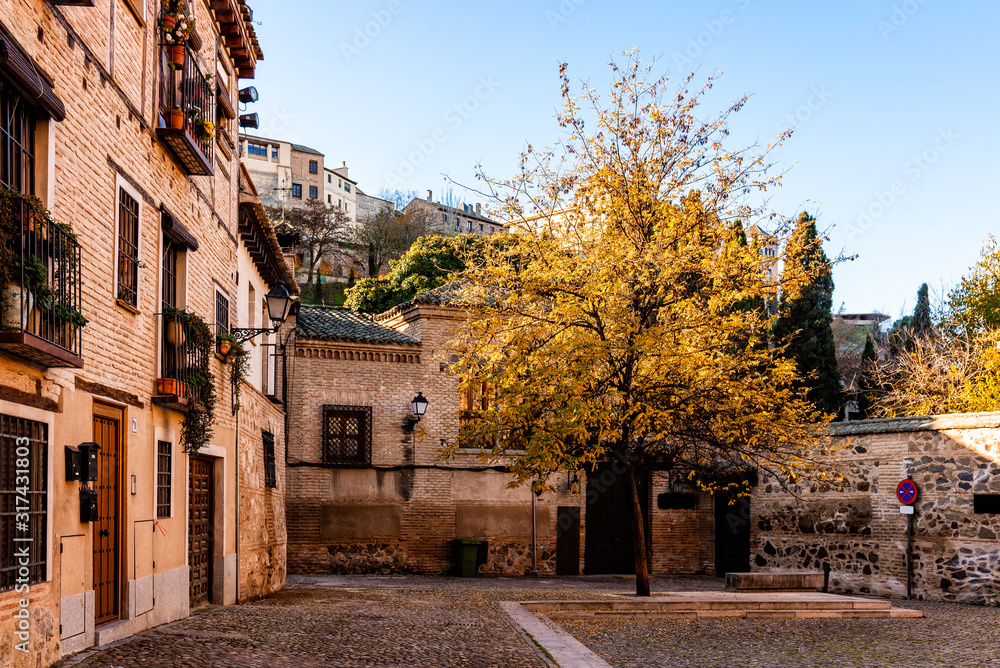 Yellow tree in medieval square in Toledo during the autumn