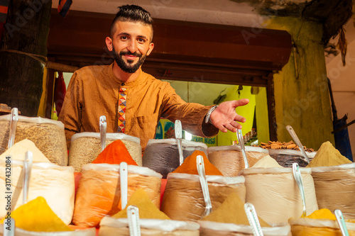 Fotografie indian sallerman showing his small shop on arambol goa market