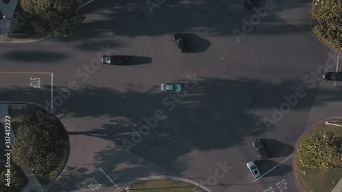 Aerial Birdseye View Rising Slowly Up of Cross Traffic Intersection in Beautiful Beverly Hills California near Los Angeles During Gorgeous Sunset Afternoon Day 4K Drone Overlooking Cars Driving