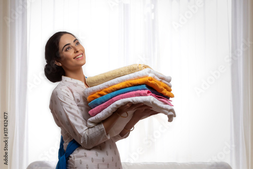 Portrait of a single woman carrying folded clothes in her hand.  photo