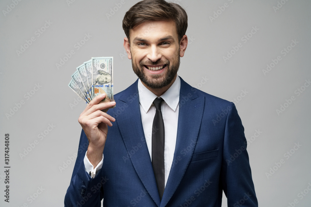 young handsome businessman holding US dollar bills young handsome businessman holding US dollar bills