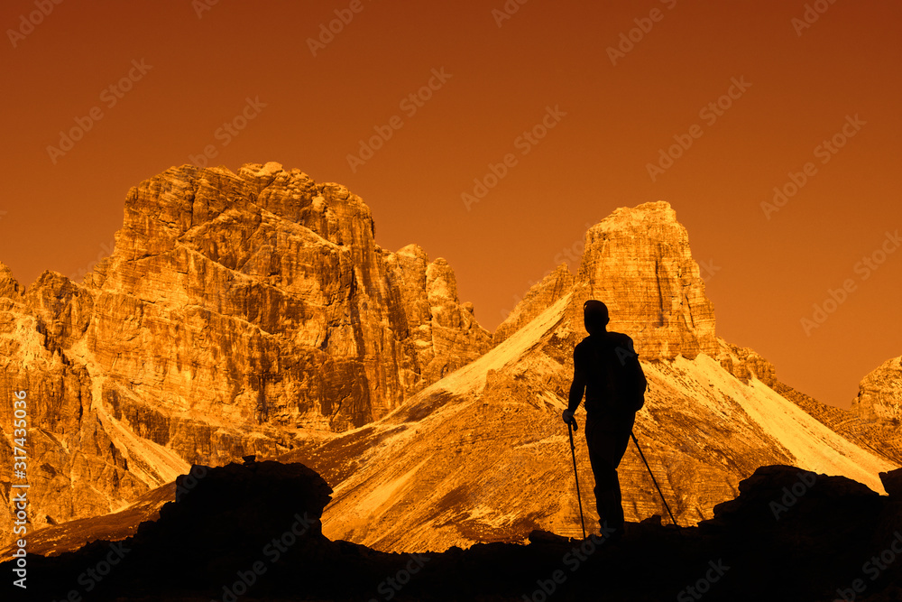 Mountain walker silhouetted against Torre dei Scarperi / Schwabenalpenkopf, Sexten Dolomites, Parco Naturale Tre Cime, South Tyrol, Italy