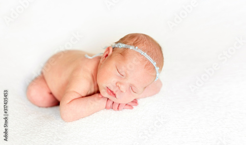 Foto Baby laying on white bedcover