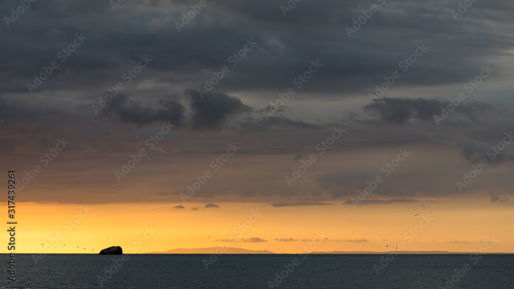 Fototapeta premium Sunset on the beaches of the Pacific Ocean in Costa Rica with a stormy sky and beautiful clouds.