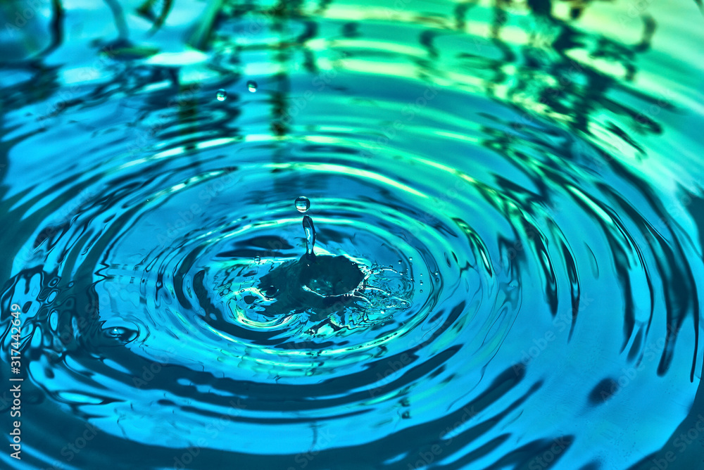 Raindrops fall on the surface of the water. The circles from the raindrops on the water surface. Abstract color background of circles on the water and falling drops. Raindrops fall on the surface of the water. The circles from the raindrops on the water surface. Abstract color background of circles on the water and falling drops.