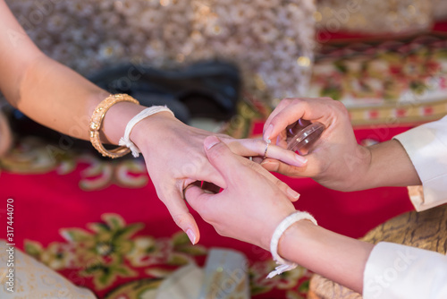 Wedding ring.Groom put the wedding ring on bride.Thai traditional wedding ceramony decoration photo