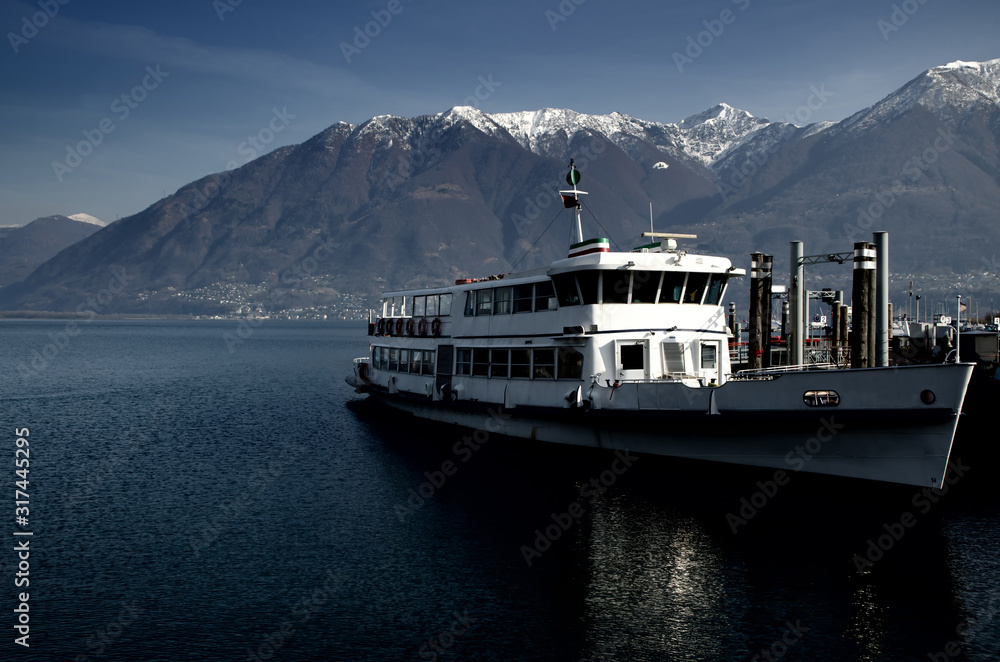 Passenger Ship on Alpine Lake Maggiore with Snow-capped mountain in Ticino, Switzerland.