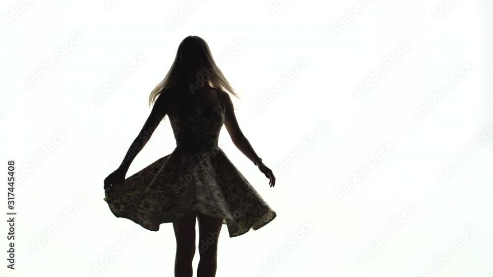 Silhouette of a young girl spinning in a dress on a white background Silhouette of a young girl spinning in a dress on a white background