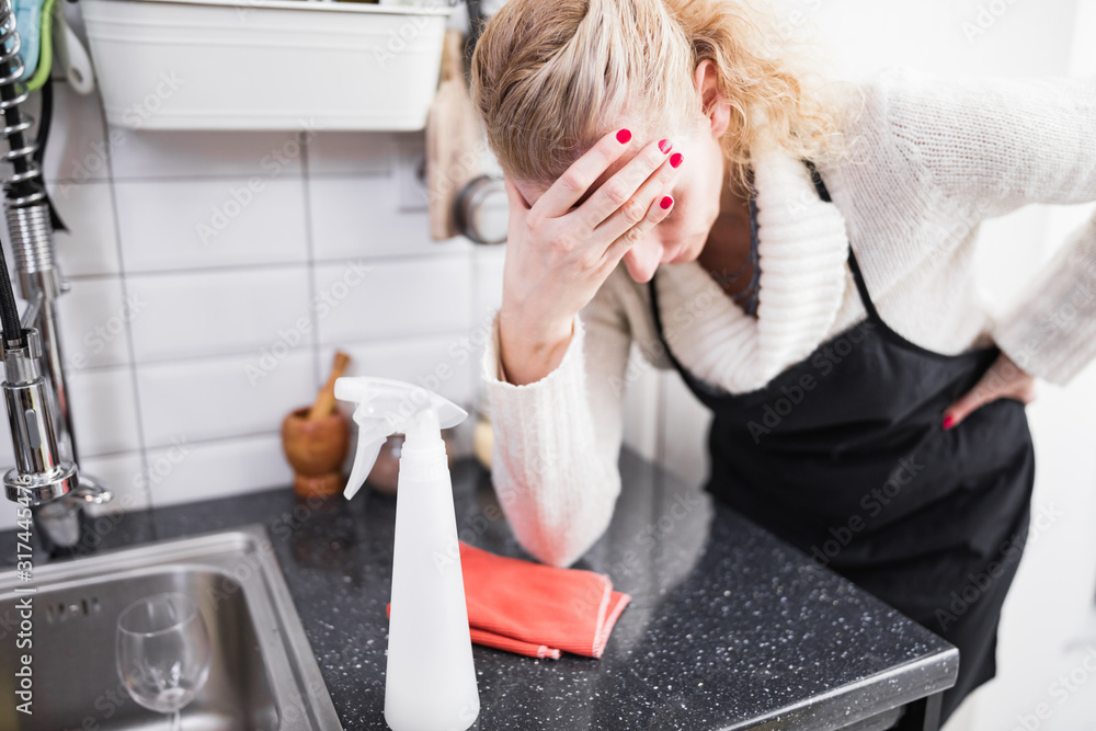 Woman tired from cleaning the house, kitchen and doing daily housework. Woman tired from cleaning the house, kitchen and doing daily housework.