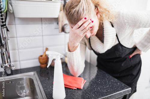 Woman tired from cleaning the house, kitchen and doing daily housework.