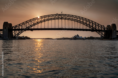 Sydney Harbour Bridge seen across the water at sunset