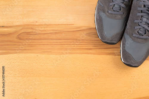 photo of new gray sneakers, sports shoes on a wooden background