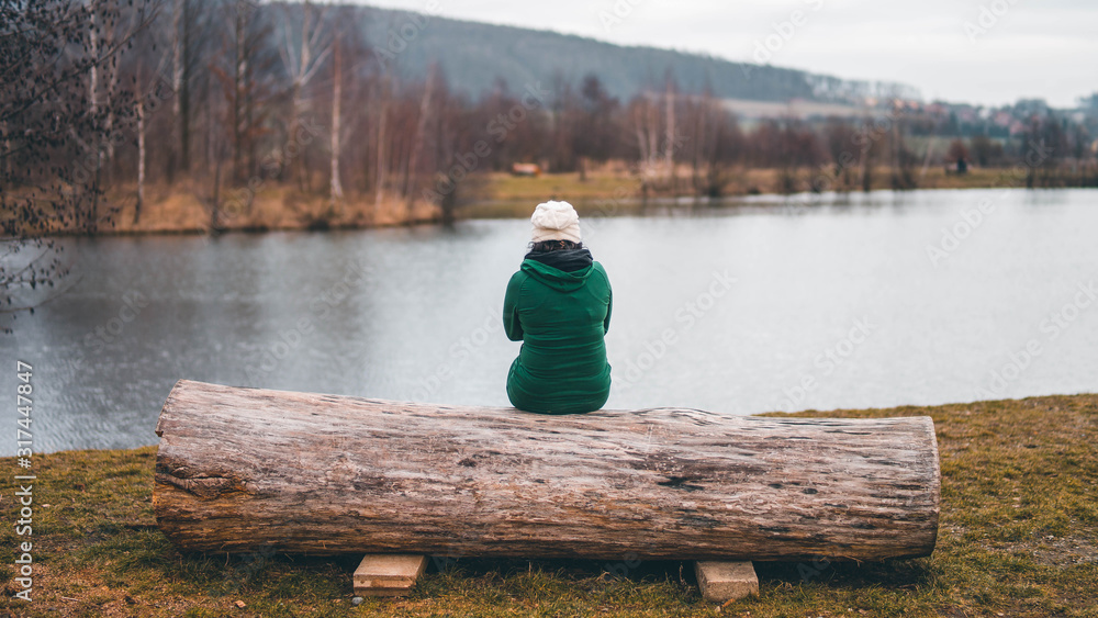 Obraz premium woman sitting by the water