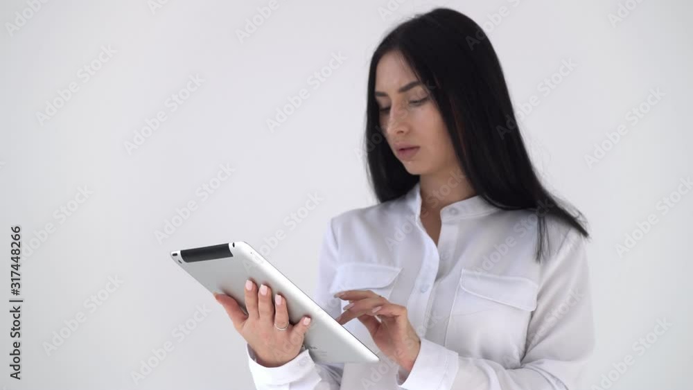 Girl freelancer working in a digital tablet. A young woman leafs through an electronic magazine in a computer tablet Girl freelancer working in a digital tablet. A young woman leafs through an electronic magazine in a computer tablet