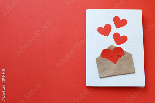 Valentine's day greeting card made with your own hands.Postcard with hearts and an envelope on a red background.Copy space.Beautiful holiday background. Declaration of love on February 14.