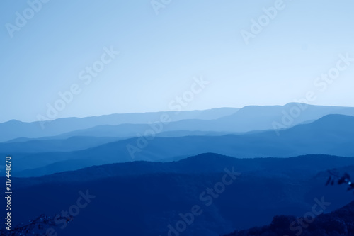 low mountains in haze. untouched mist nature away from man  toned in trendy Classic Blue color of the Year 2020 © sommersby