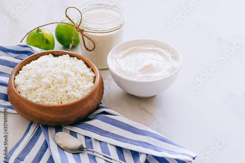 Healthy breakfast of cottage cheese with sour cream and lime on a marble table