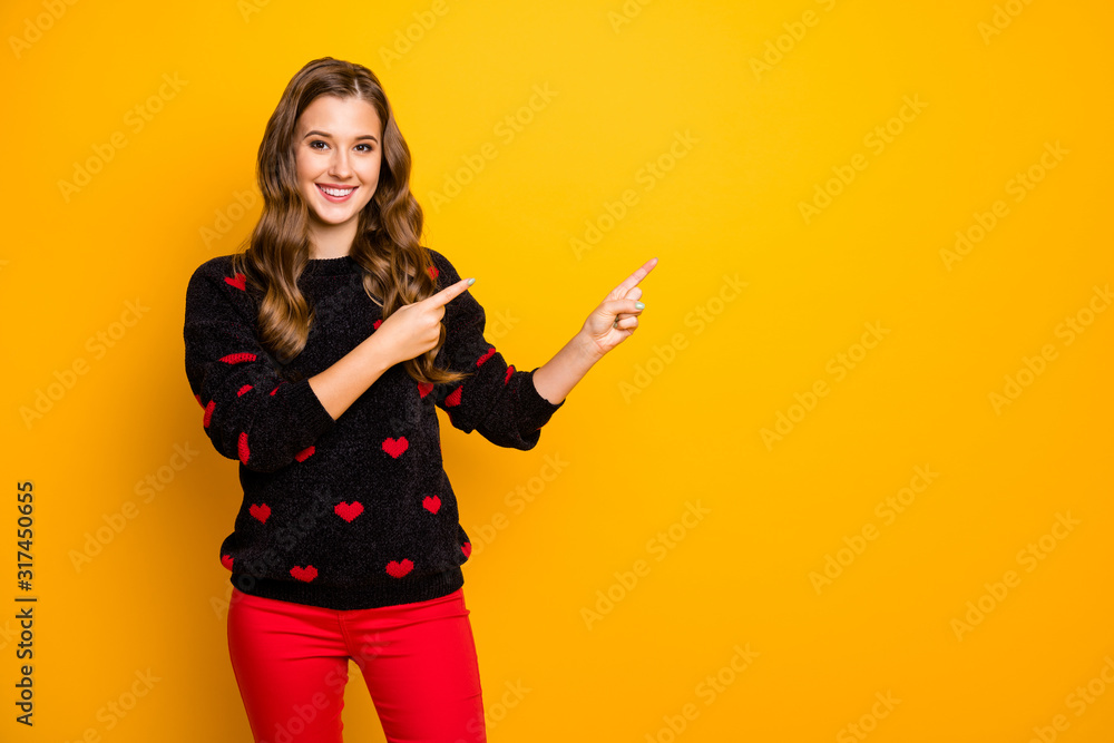 Photo of pretty lady indicating finger empty space advising low discount shopping season prices wear hearts pattern pullover red pants isolated yellow color background Photo of pretty lady indicating finger empty space advising low discount shopping season prices wear hearts pattern pullover red pants isolated yellow color background
