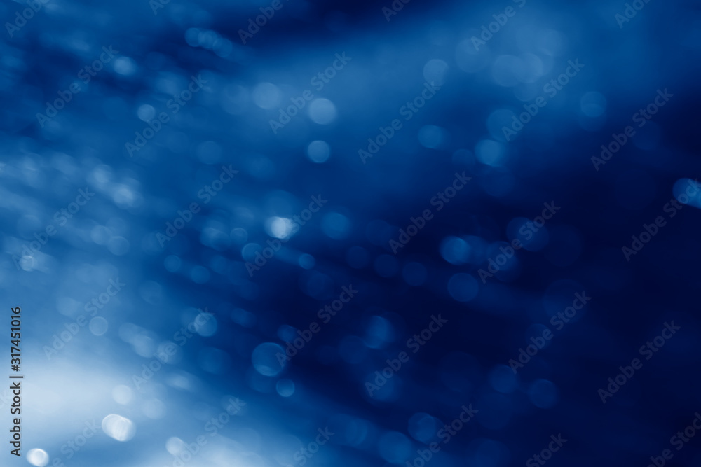 abstract blurred natural background with bokeh effect toned in trendy Classic Blue color of the Year 2020 abstract blurred natural background with bokeh effect toned in trendy Classic Blue color of the Year 2020