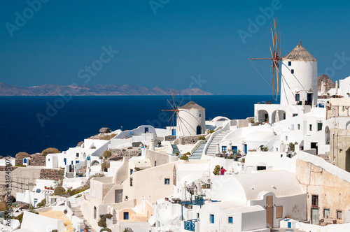 Whitewashed Greek island architecture with classic Mediterranean windmills on a hillside in Santorini, Greece