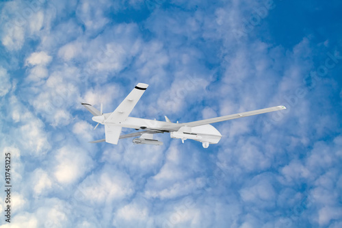 RC military drone flies against the backdrop of blue peaceful sky with white clouds