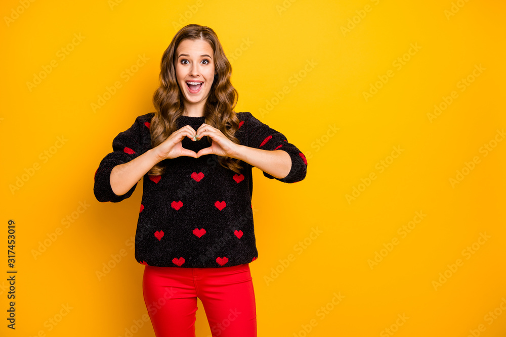 Photo of excited funny curly lady inviting boyfriend romantic date showing arms heart shape figure wear black red hearts pattern sweater trousers isolated yellow color background Photo of excited funny curly lady inviting boyfriend romantic date showing arms heart shape figure wear black red hearts pattern sweater trousers isolated yellow color background