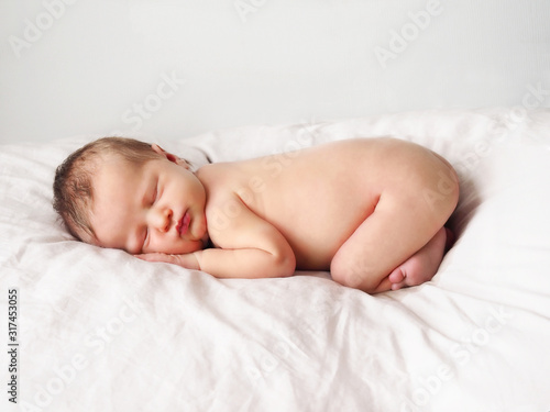 Newborn girl. Naked newborn girl is sleeping. Newborn baby on white.