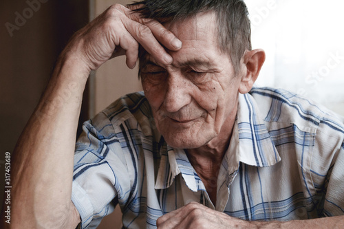Wallpaper Mural Senior sitting at the table and thinking about something or forg Torontodigital.ca