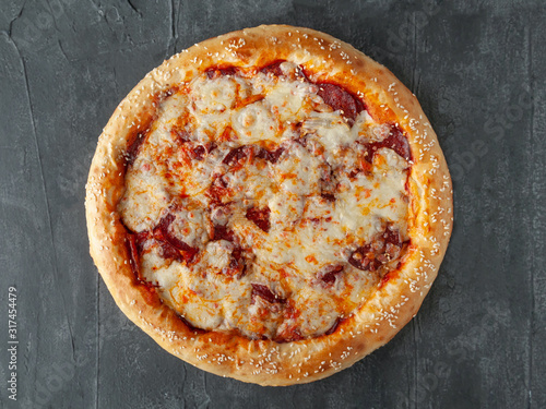 Italian pepperoni pizza. With pepperoni sausage, tomato sauce, Mozzarella cheese, Sulguni and Parmesan. Wide side. View from above. On a gray concrete background. Isolated.
