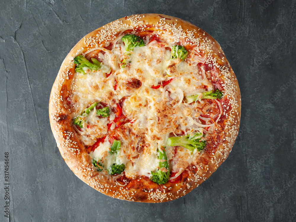 Italian pizza vegetarian. with Broccoli, tomatoes, onions, tomato sauce, mozzarella and sulguni. A wide side. View from above. On a gray concrete background. Isolated.