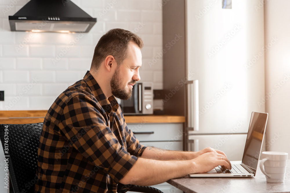 Guy with a cup of coffee is working on a laptop. Guy with a cup of coffee is working on a laptop.