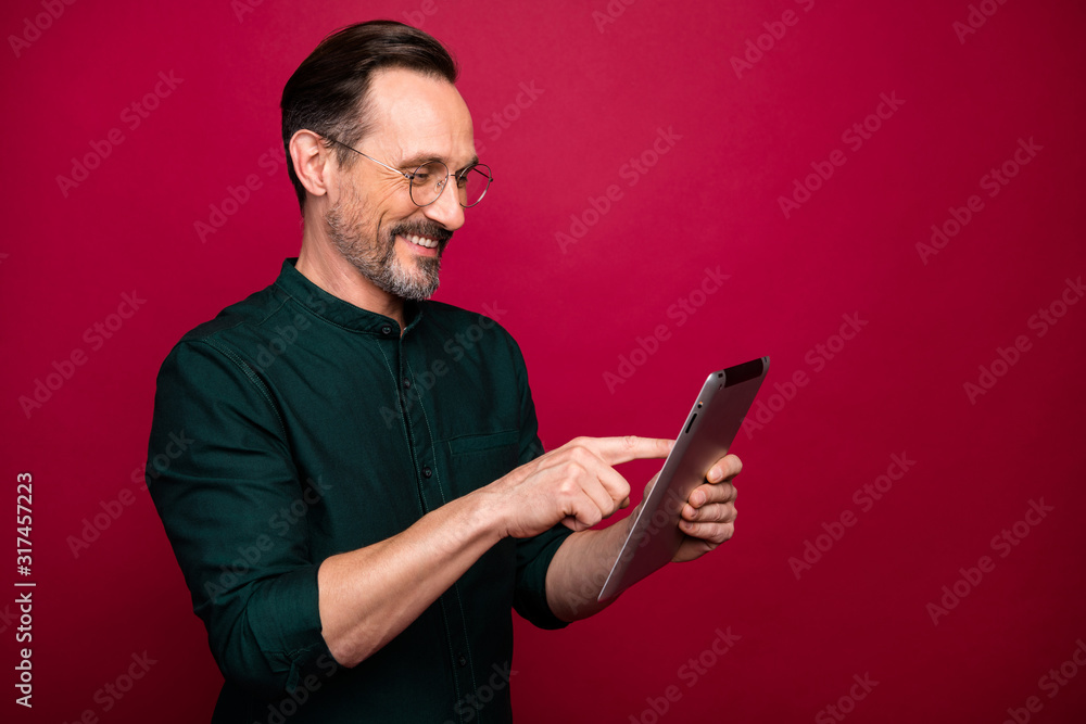 Turned photo of man browsing through modern gadget testing how different applications work on this device isolated red vivid color background Turned photo of man browsing through modern gadget testing how different applications work on this device isolated red vivid color background