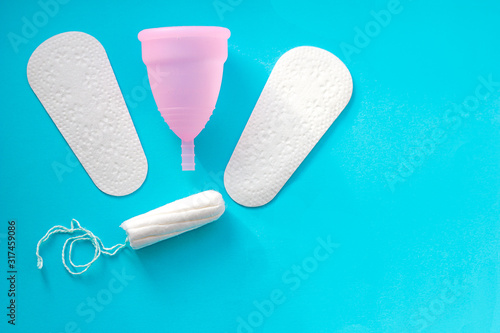 Sanitary pad, menstrual cup and tampon on pink background, space for text photo