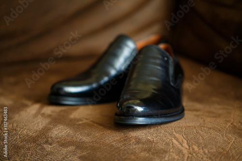 black leather shoes on a brown background