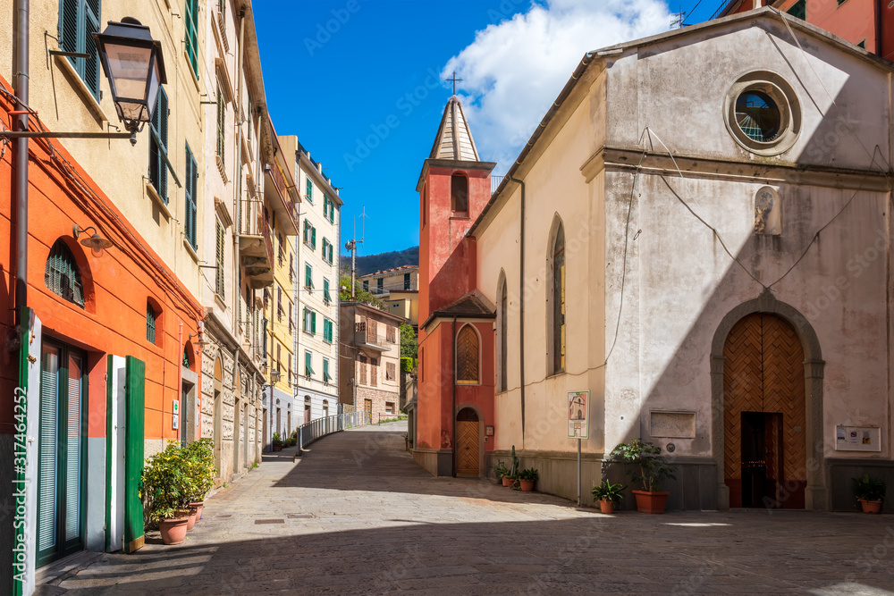 Beautiful view of narrow street with colorful buildings in Riomaggiore - one of five famous colorful villages of Cinque Terre National Park in Italy, Liguria region.