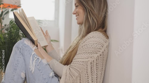 beautiful young woman reading a book and smiling.