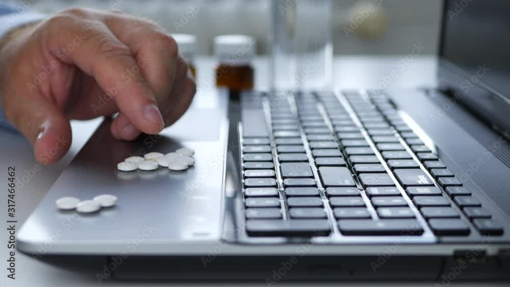 Man Feeling Sick Select Medical Pills from Laptop Surface in Office Room Man Feeling Sick Select Medical Pills from Laptop Surface in Office Room