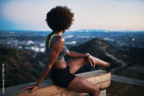 fit african woman woman resting on bench at runyon canyon shortly after sunset