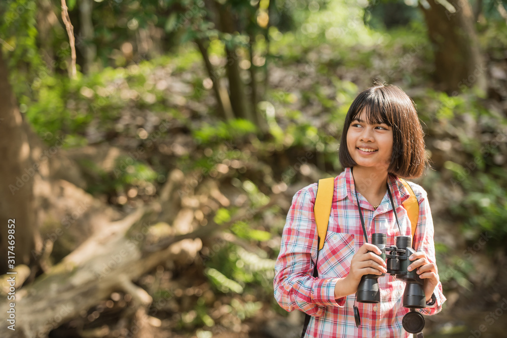 hiking women use binoculars to travel and have a happy smile. tourist looking through binoculars considers wild birds in the jungle. bird watching tours. with backpack. travel concept hiking women use binoculars to travel and have a happy smile. tourist looking through binoculars considers wild birds in the jungle. bird watching tours. with backpack. travel concept
