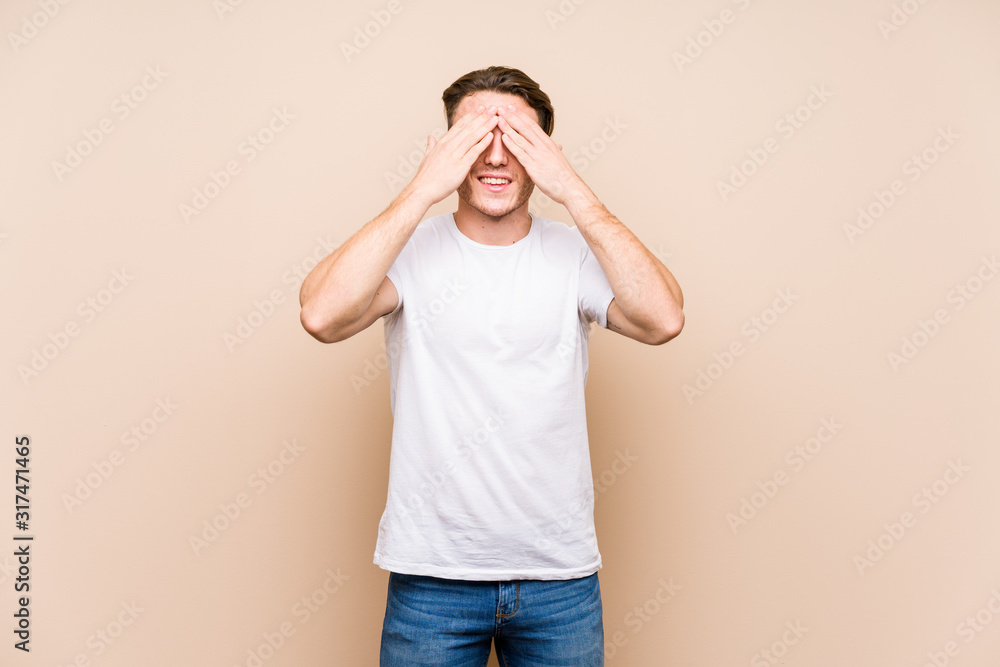 Young caucasian man posing isolated covers eyes with hands, smiles broadly waiting for a surprise. Young caucasian man posing isolated covers eyes with hands, smiles broadly waiting for a surprise.