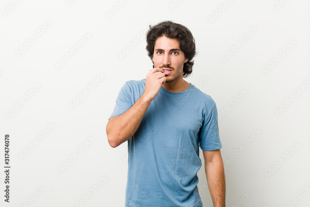 Young handsome man against a white background biting fingernails, nervous and very anxious. Young handsome man against a white background biting fingernails, nervous and very anxious.