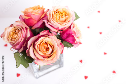Pink roses and heart shape ornaments on white background