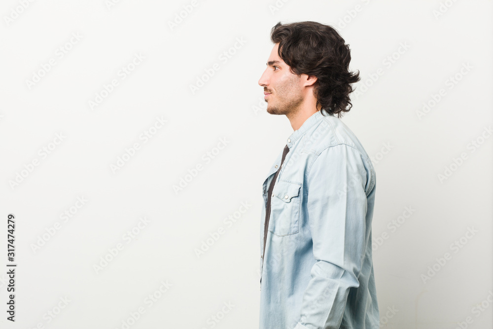 Young handsome man against a white background gazing left, sideways pose. Young handsome man against a white background gazing left, sideways pose.