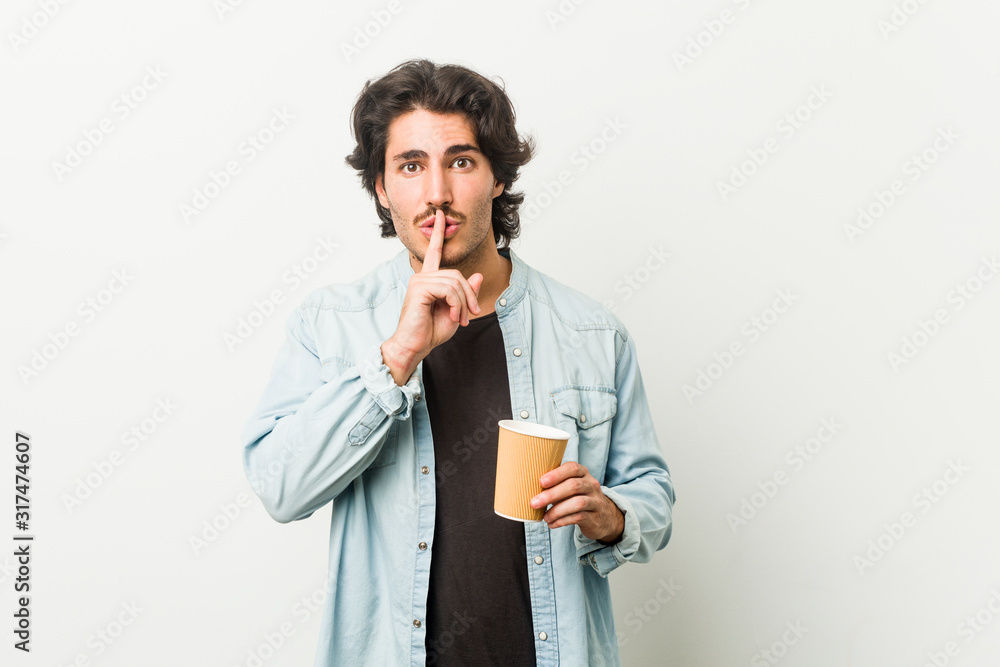 Young cool man drinking a coffee keeping a secret or asking for silence. Young cool man drinking a coffee keeping a secret or asking for silence.