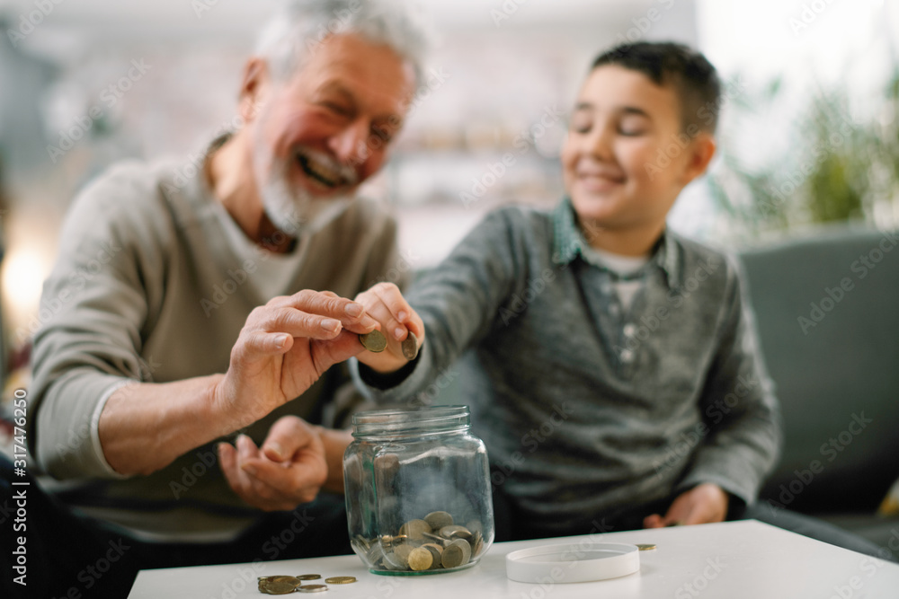 Grandpa and grandson saving money. Grandfather teaching grandchild how to save money. Grandpa and grandson saving money. Grandfather teaching grandchild how to save money.