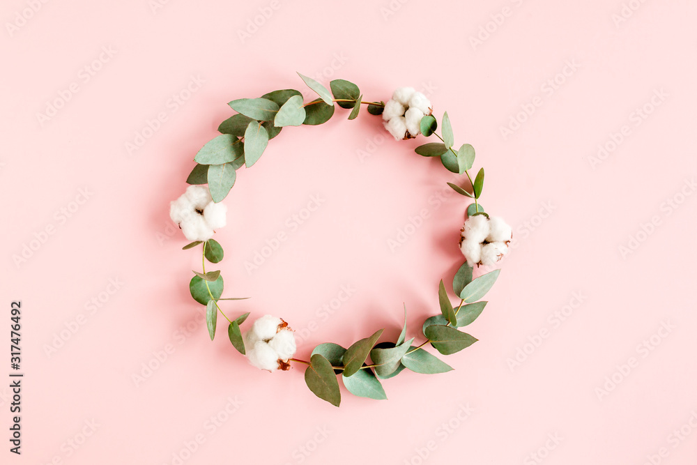 Round frame with branches eucalyptus and cotton isolated on pink background. lay flat, top view